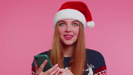 woman in stylish christmas sweater looking smartphone display sincerely rejoicing win success luck