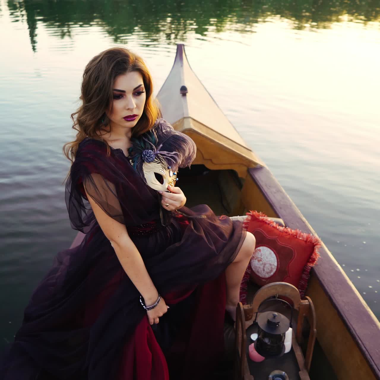 Giovane donna in abito rosso in barca sul fiume. Donna in gondola