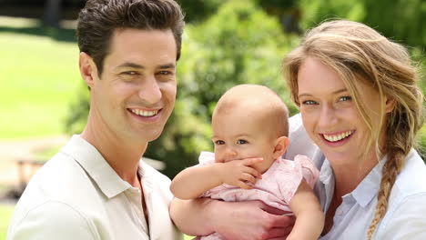 Padres-Felices-Con-Su-Niña-En-El-Parque