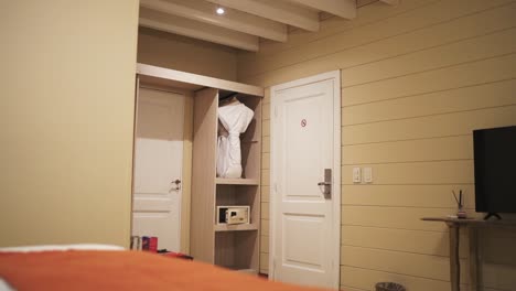 a slow-moving shot glides over the bed, revealing the hotel room closet and door against bright yellow walls, highlighting the vibrant decor and inviting atmosphere