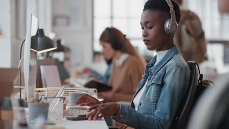 Joven-Mujer-De-Negocios-Afroamericana-Que-Usa-Una-Computadora-Escribiendo-En-El-Teclado-Enviando-Correos-Electrónicos-En-Red-En-Una-Oficina-Ocupada-Revisando-El-Teléfono-Inteligente