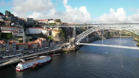 drone disparado volando bajo y hacia atrás con el puente a la vista en porto portugal al atardecer