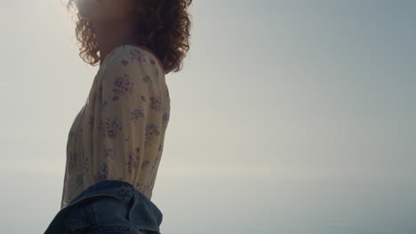 beautiful lady enjoy sunshine standing on sea beach close up. curly woman posing