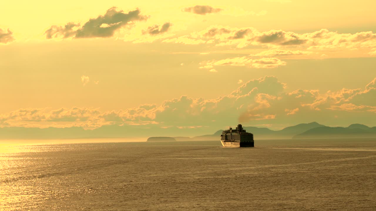 해안 을 따라 산 들 이 있는 황금빛 해 가 지는 동안 항해 하는 크루즈 선박