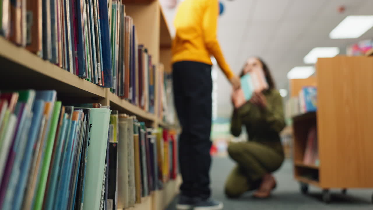 A woman and child in a library looking at books