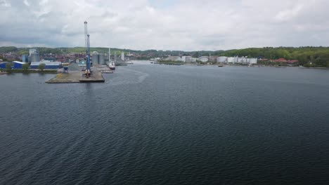 aabenraa harbor view with industrial buildings and calm water, shot from a drone