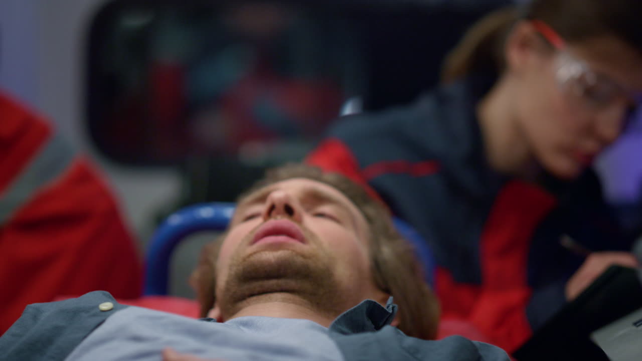 응급 차량 에 있는 베개 에 누워 있는 환자. 배 에 통증 을 느끼는 사람