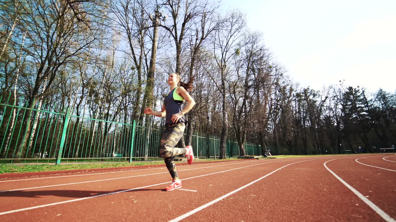 Track runner woman running on stadium. Ideal female figure. Sport.