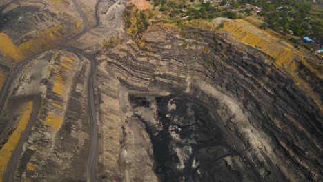 high-altitude aerial shot of coal mining operations in dhanbad, with heavy equipment in action.