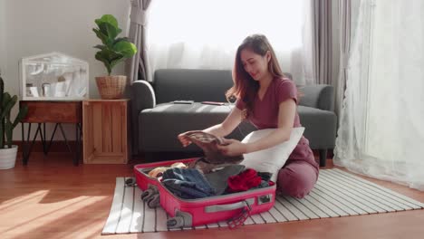 cute woman folded clothes and packed a suitcase to happily prepare for a trip