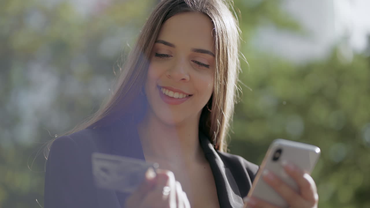 mujer joven sonriente con teléfono inteligente y tarjeta de crédito