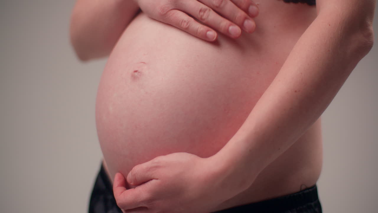 Donna in gravidanza avanzata che si massaggia la pancia