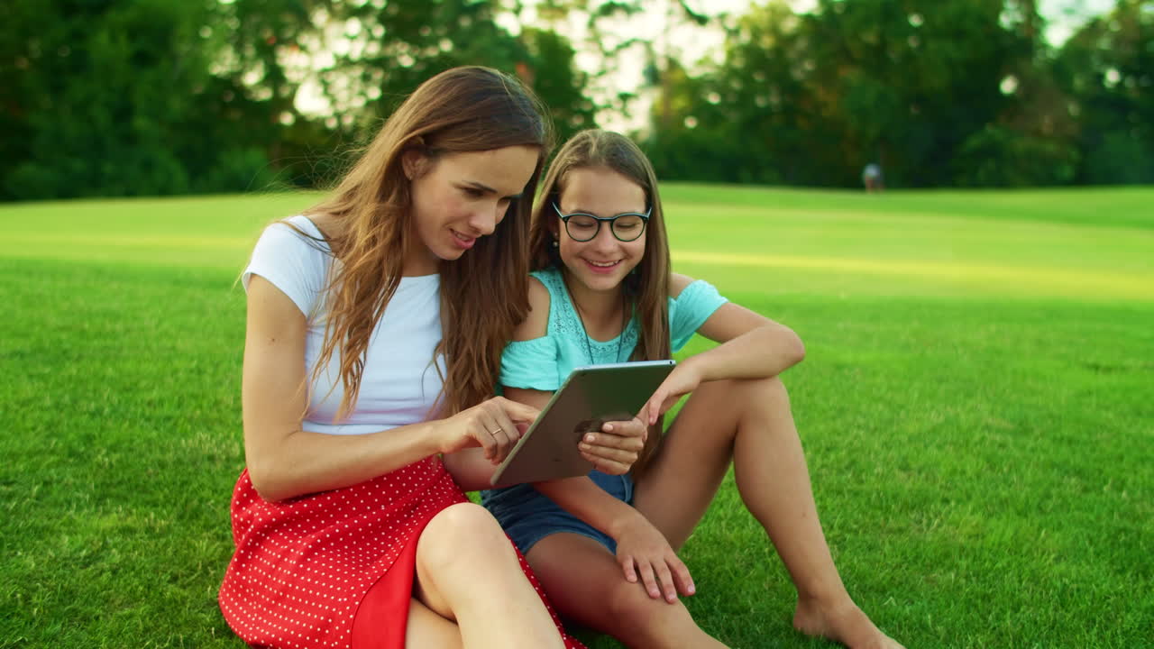 mujer y niña usando una tableta. madre e hija navegando por internet en una tableta
