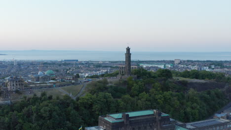Aerial-shot-rising-over-Edinburgh,-looking-out-over-crowds-of-tourists-on-Calton-Hill