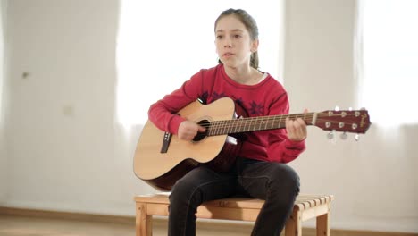 una joven tocando la guitarra y cantando