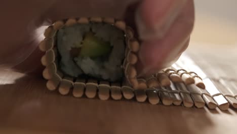 chef rolling sushi rolls in the kitchen