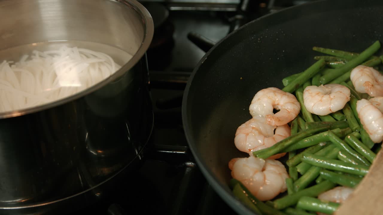 Noodles Boiling Next to King Prawns with Green Beans in Hot Pan
