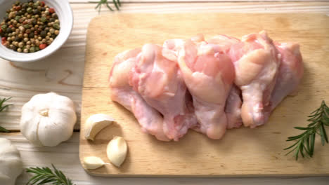 alitas de pollo crudas frescas en tablero de madera con ingredientes