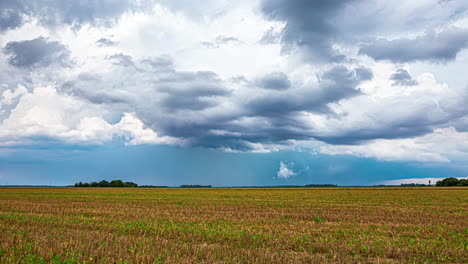 Paisaje-Nublado-Y-Tormenta-De-Lluvia-Mientras-Una-Cosechadora-Recoge-Cultivos---Lapso-De-Tiempo