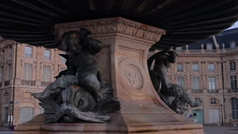 close up of the bordeaux symbol and logo on the fountain of the three graces at place de la bourse during sunrise