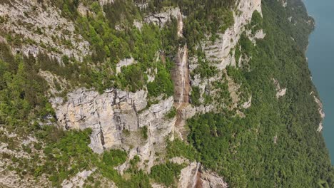 a striking view of seerenbachfälle, switzerland, showcases multiple waterfalls cascading down vast, green-clad cliffs, with glimpses of a turquoise lake