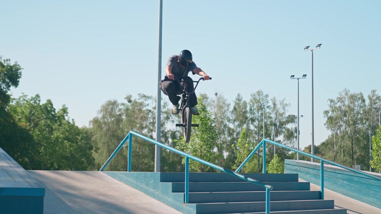BMX-cyklist hopper over gelænder i skatepark i slowmotion