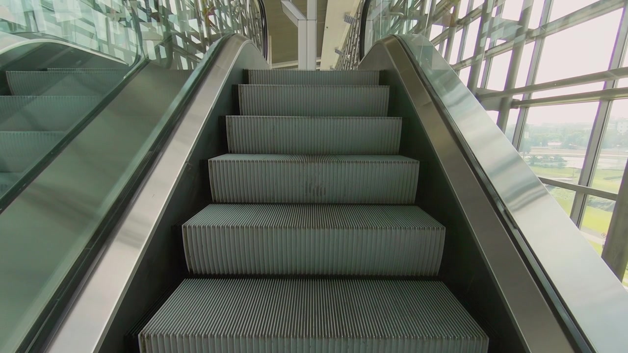 Escalators en mouvement, allant de haut en bas. Vidéo en vue subjective.