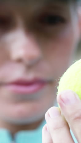 retrato de una deportista mirando una pelota de tenis
