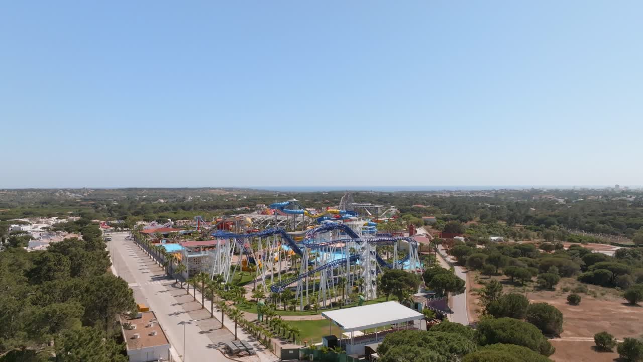 parques de toboganes de agua naranja azul brillante en el algarve, portugal, dolly aéreo inverso