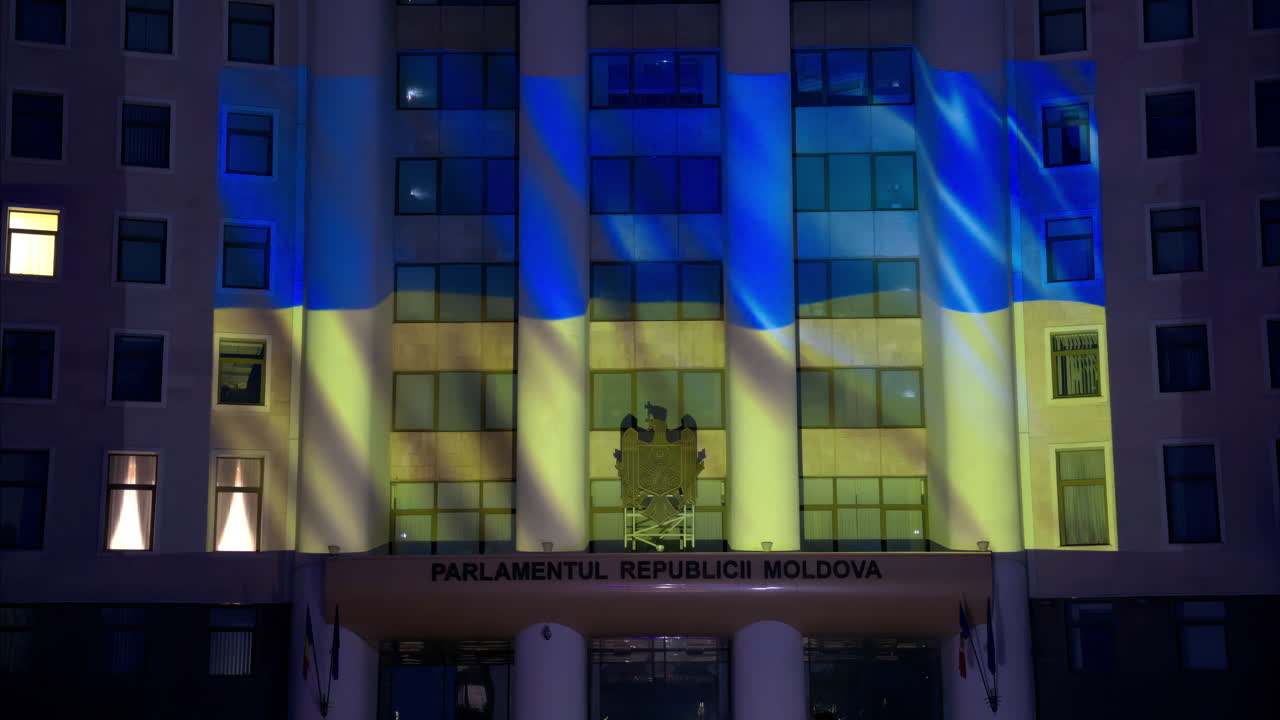 The flag of Ukraine projection on the facade of the Parliament of Moldova in the evening