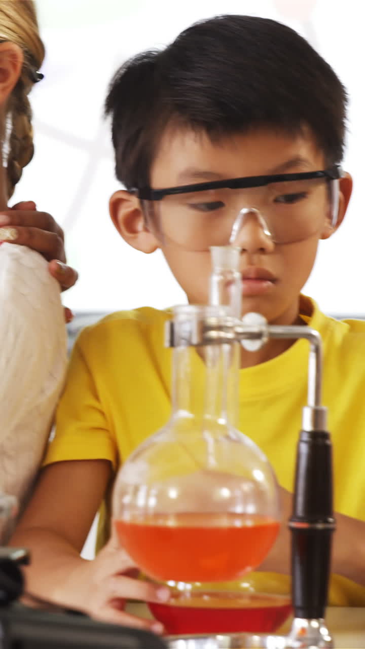 niños de la escuela haciendo un experimento químico en el laboratorio