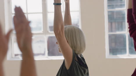 yoga class beautiful middle aged woman practicing warrior pose enjoying healthy lifestyle group meditation in fitness studio