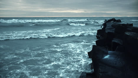 Mächtige-Isländische-Sturmwellen,-Die-Gegen-Schwarze-Strandfelsen-Krachen