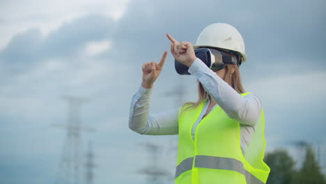 Porträt-Einer-Modernen-Frau-Des-Kontrollbeamten-Des-Ingenieurs,-Der-Die-Inspektion-über-Eine-Virtual-Reality-Brille-Und-Einen-Weißen-Helm-In-Uniform-Durchführt,-Im-Hintergrund-Die-Türme-Der-Macht.