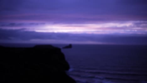 hombre con vistas a los acantilados y el mar durante una cautivadora puesta de sol púrpura