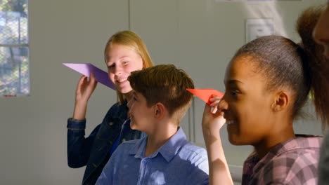 niños lanzando aviones de papel en el instituto de entrenamiento 4k