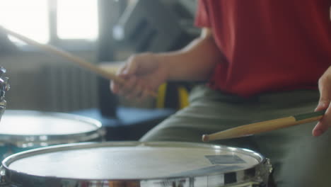 close-up of a person playing drums with drumsticks