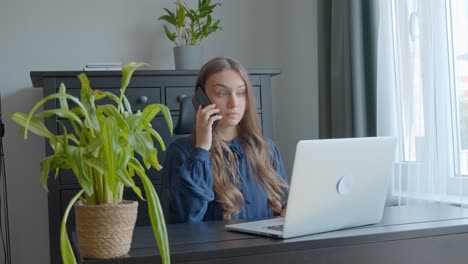 worried woman on a phone call while at work surprise blink and touch forehead