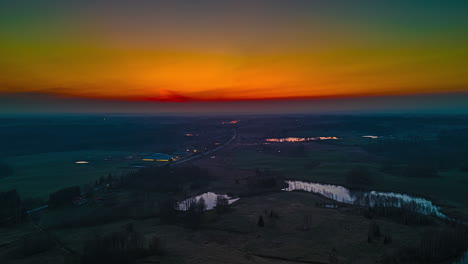 colorful sky during sunset over countryside road near small ponds. timelapse