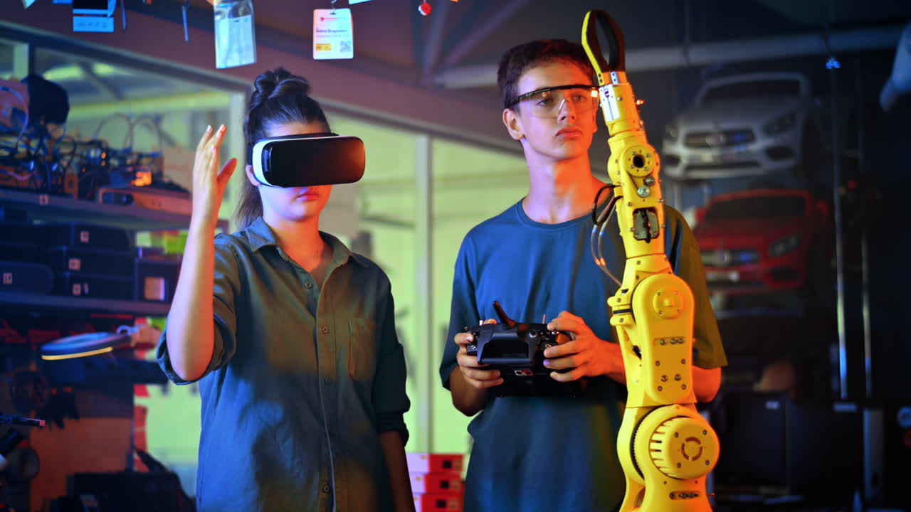 Teens doing experiments in robotics in a laboratory. Boy in protective glasses and girl in VR headset controlling the robot using controller and hand. Red and blue illumination. Slow motion