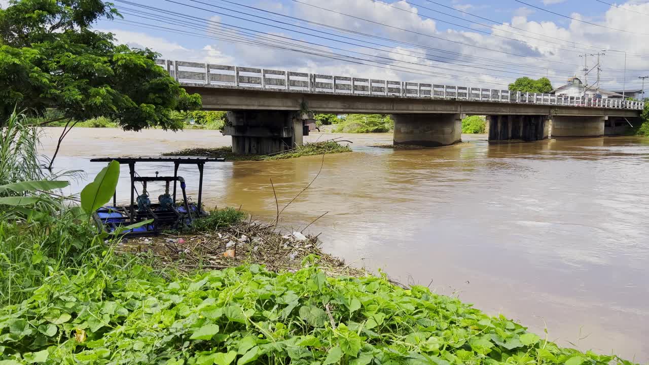 태풍 후 높은 물과 함께 강 위의 다리를 통해 운전하는 자동차