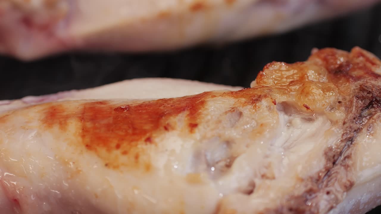 Roasted rabbit legs in a grill pan, healthy diet meat close up, chef cooking rabbit on kitchen restaurant, Black background. Top view