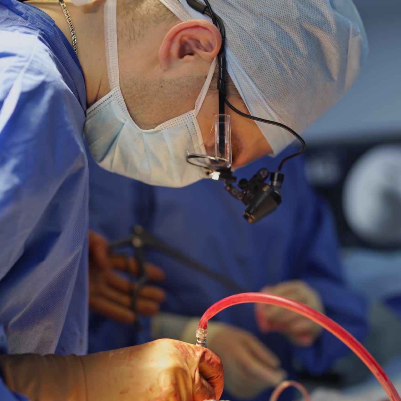 Operation by professional surgeon. Medical specialist together with female assistant perform a surgery using sterile surgical instruments. Close-up