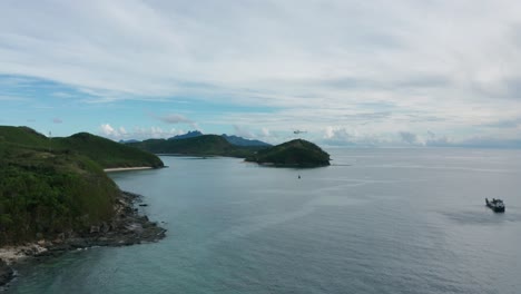 helicóptero volando lejos de la barcaza a la isla con una bolsa cargada de suministros, fiji