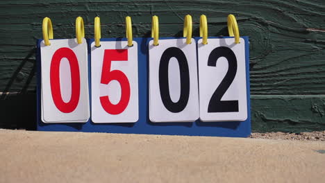 scoreboard blows in wind at baseball softball kickball game in sliding motion