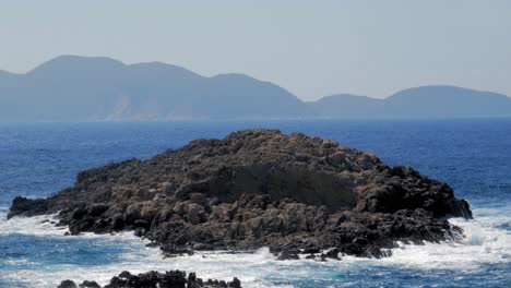 ocean waves crashing on coastal rocks in jerusalem beach, greece at daytime - static shot