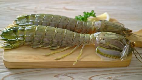 fresh mantis shrimp with lemon on wood board