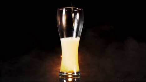 Wheat-Beer-Is-Being-Poured-Into-Weizen-Glass,-White-Bubbles-Emerge-With-Smoky-Background