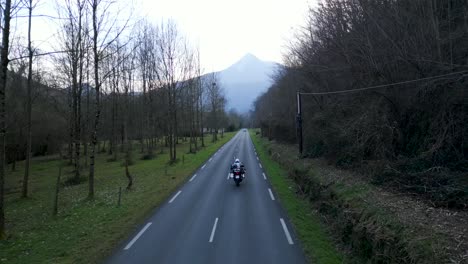 motorcyclist on a scenic road through a mountain valley