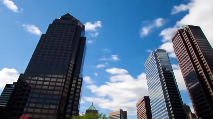 Breathtaking Cityscape Under a Vibrant Sky: A Stunning View of Towering Skyscrapers Against Fluffy Clouds and Brilliant Blue Atmosphere